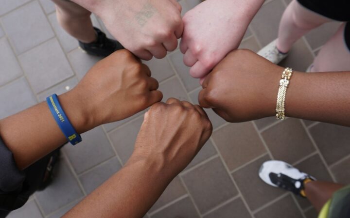 A diverse group of people joining hands together in a circle