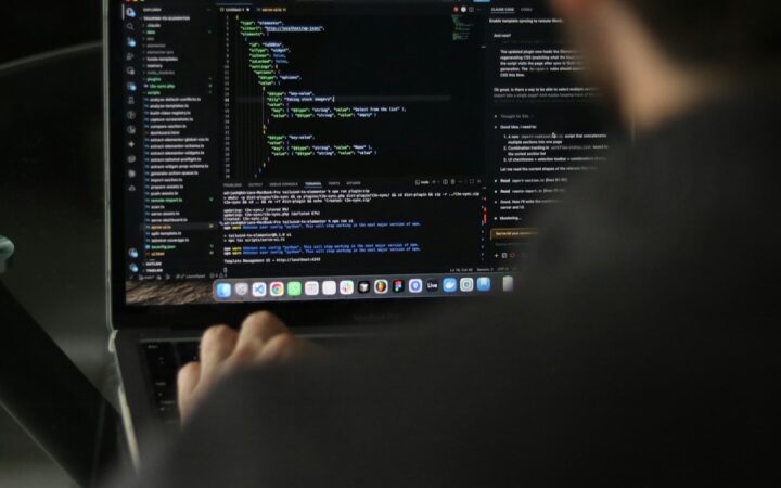 Developer working on source code in a laptop programming environment