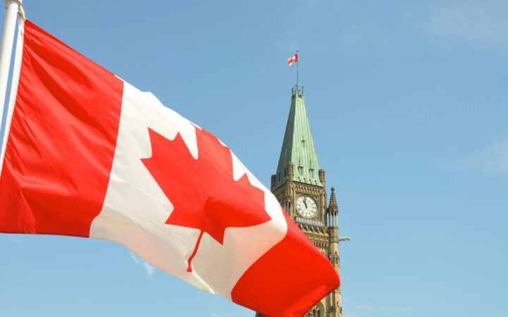 Canadian maple leaf flags beside the Peace Tower at Parliament Hill in Ottawa