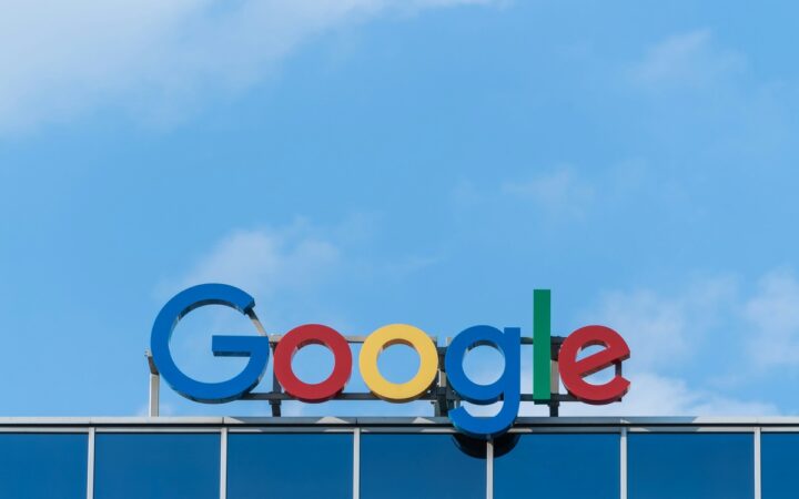 Colorful Google sign above a glass building against a blue sky in Wrocław, Poland