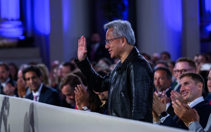Jensen Huang raises his hand at the White House AI Summit in Washington on July 23, 2025